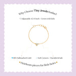 Tiny Jewels gold bracelet with text on a light purple background