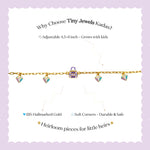 Tiny Jewels gold necklace with colorful charms on a white card with promotional text on a purple background