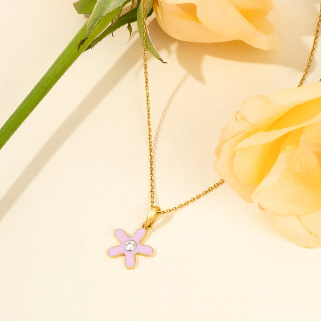 Tiny Jewels gold necklace with a pink flower pendant on a yellow background with flowers Itsy Flower Pendant.