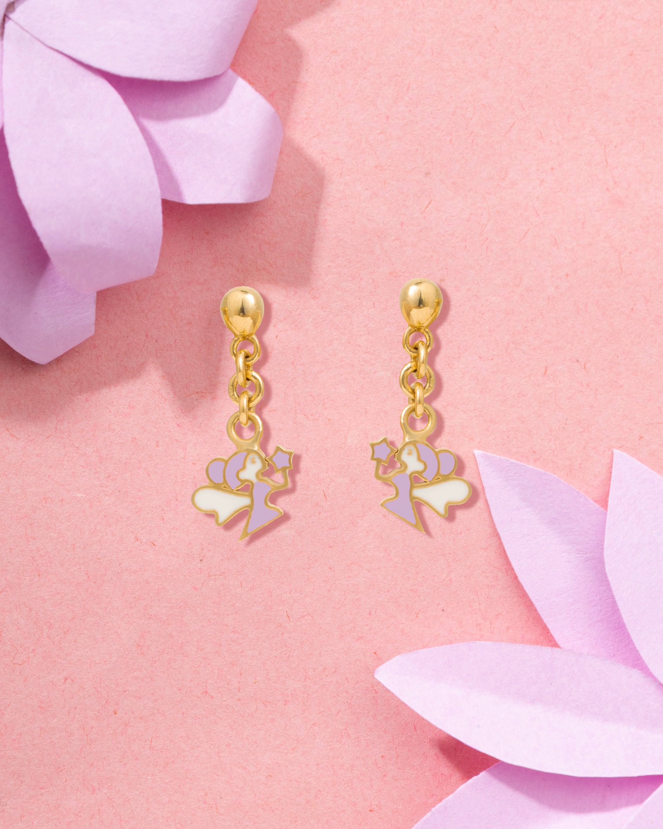 Tiny Jewels gold earrings with heart and flower charms on a pink floral background