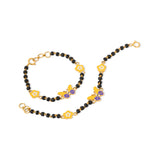 Tiny Jewels black beaded necklace with gold and purple floral accents on a white background