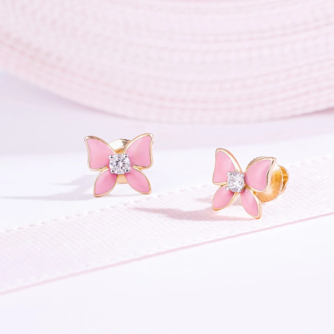 Tiny Jewels pink butterfly earrings with gold accents on a light pink background