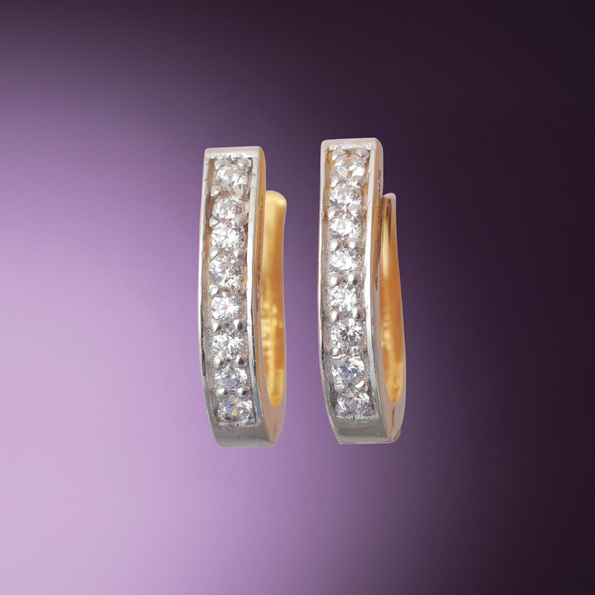 Tiny Jewels pair of gold hoop earrings with embedded diamonds on a purple background