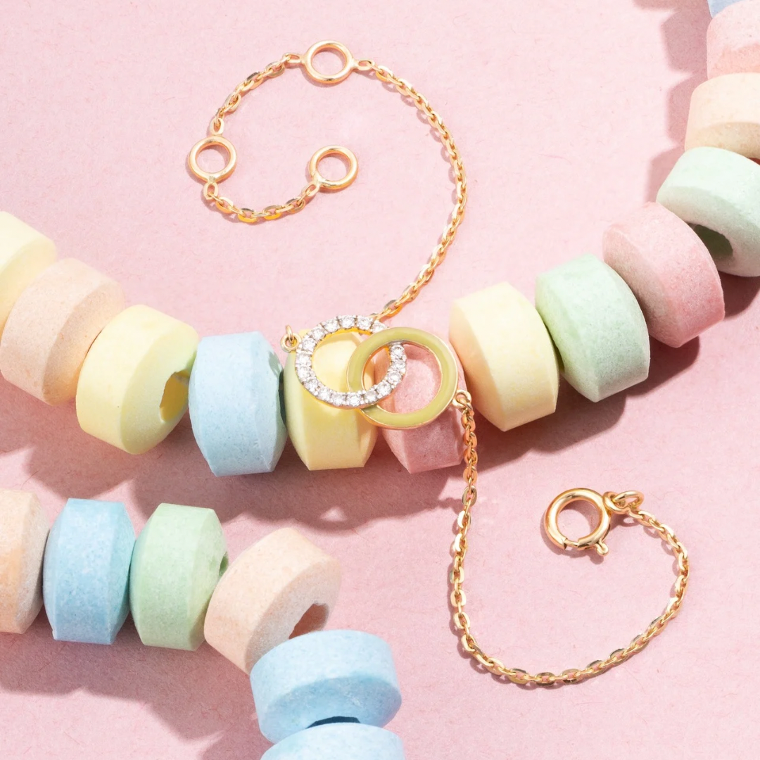 Tiny Jewels pastel-colored beaded necklace with gold chain on a pink background