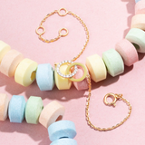Tiny Jewels pastel-colored beaded necklace with gold chain on a pink background