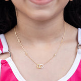 Tiny Jewels gold necklace with interlocking rings worn by a person