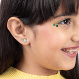 Tiny Jewels close-up of a girl wearing colorful earrings with a neutral background