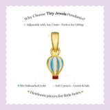 Tiny Jewels Gold hot air balloon pendant with text on a light purple background