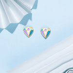 Tiny Jewels colorful gemstone earrings on a light blue fabric background