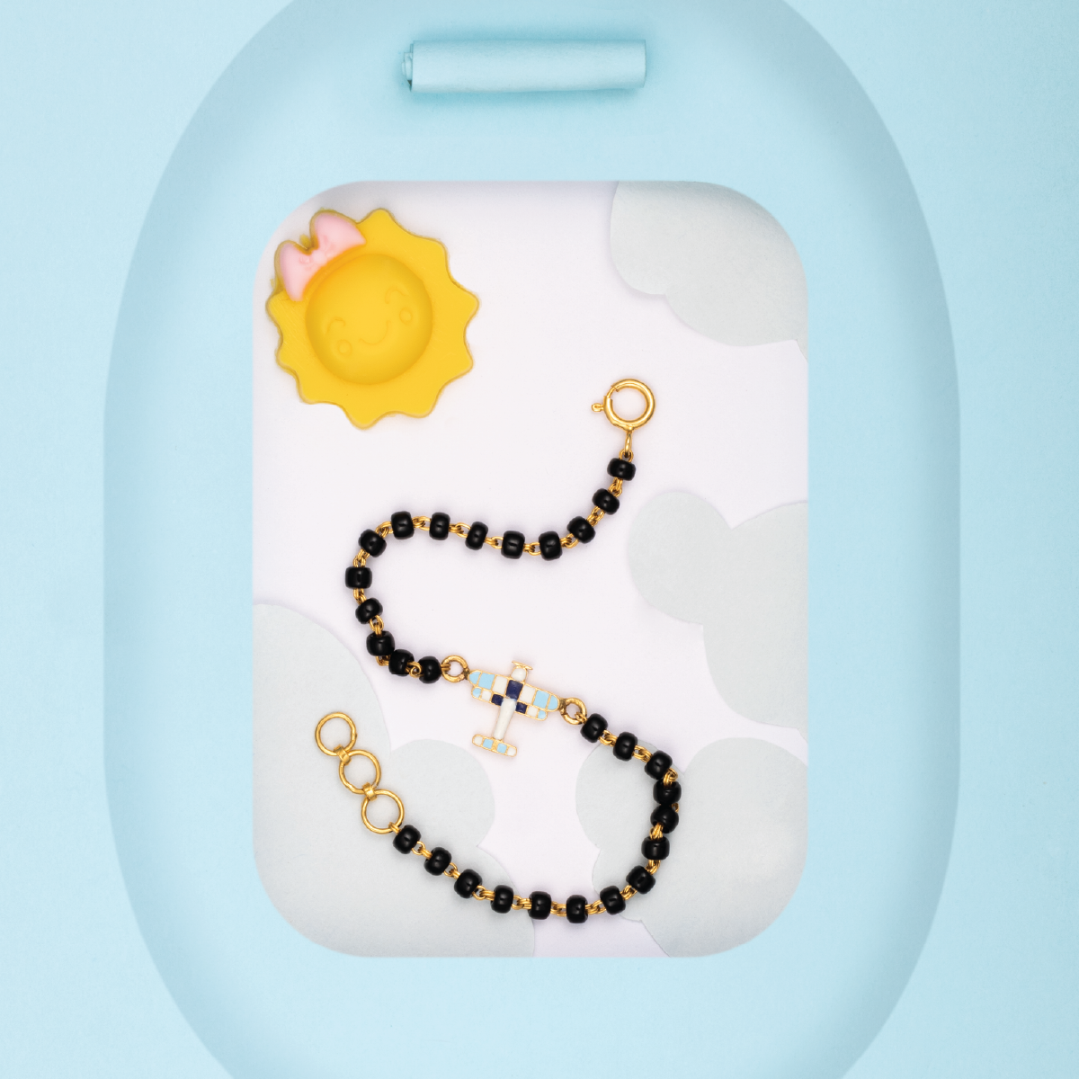 Tiny Jewels black and gold beaded bracelet on a white stand with a blue background