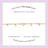 Tiny Jewels gold bracelet with heart-shaped charms on a white background with text about Tiny Jewels Kadas.