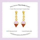 Tiny Jewels ice cream cone-shaped earrings with gold and pink details on a purple background