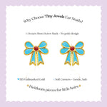 Tiny Jewels bow-shaped earrings with gold and turquoise design on a light purple background