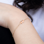 Tiny Jewels rose gold bracelet with star-shaped charms on a wrist against a neutral background