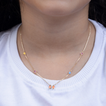 Tiny Jewels necklace with colorful beads worn by a person on a white background