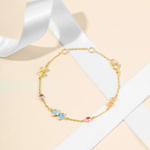 Tiny Jewels gold bracelet with colorful beads on a light background