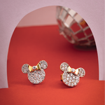 Tiny Jewels gold and diamond-encrusted earrings on a red and pink background