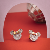 Tiny Jewels gold and diamond-encrusted earrings on a red and pink background