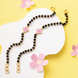 Tiny Jewels black beaded necklace with pink flower charms on a yellow background