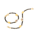 Tiny Jewels bracelet with black beads and gold heart-shaped charms on a white background