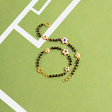 Tiny Jewels bracelet with floral beads on a green background
