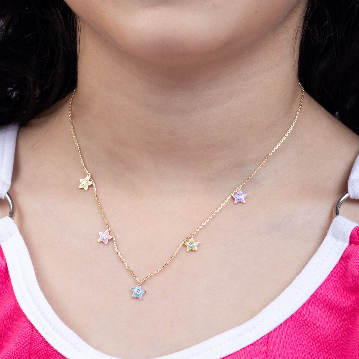 Tiny Jewels necklace with star-shaped pendants worn by a person