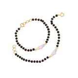 Tiny Jewels black beaded necklace with gold accents on a white background