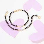 Tiny Jewels black beaded necklace with gold accents on a white background